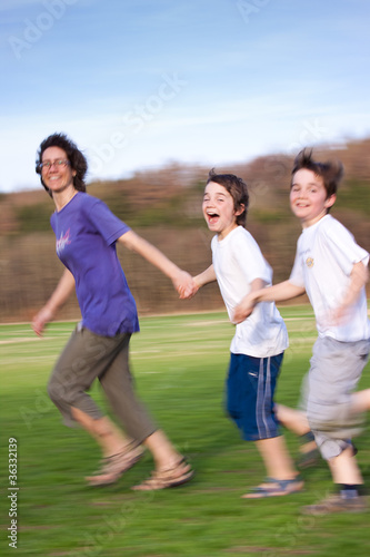Aktive Mutter läuft mit zwei glücklichen Kindern