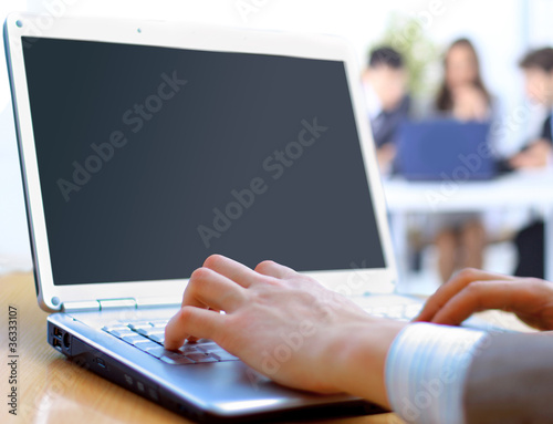 Person Typing on a modern laptop in an office