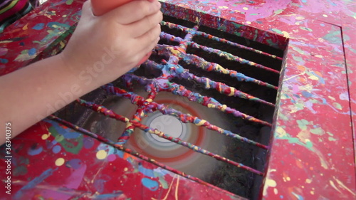 Kid hands making art with spinning disk