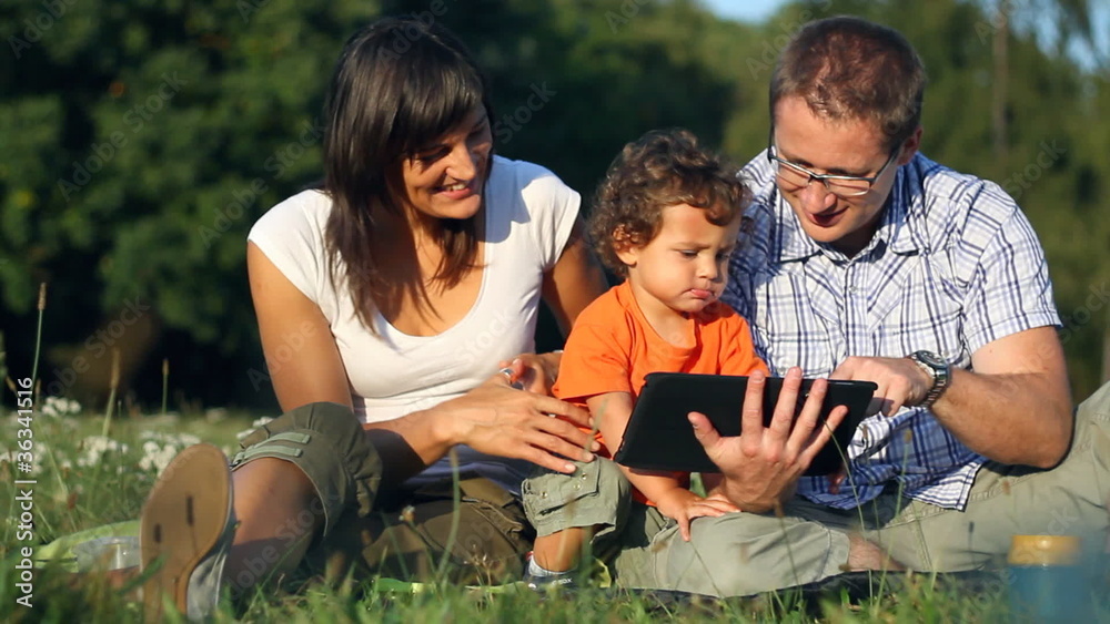 Happy family with tablet computer in the park Happy family with tablet computer in the park