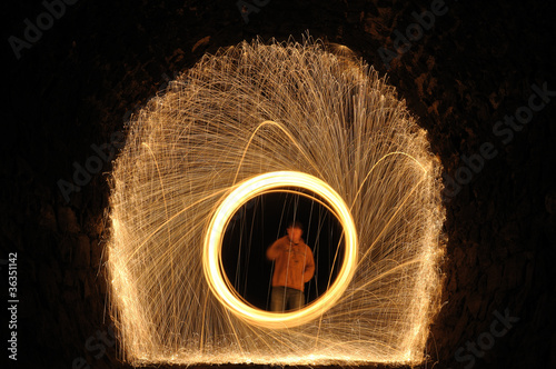 person in a ring burning steel in a dark tunnel