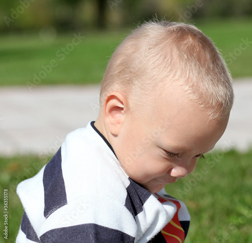 Portrait of unhappy punished little boy deploring outdoor