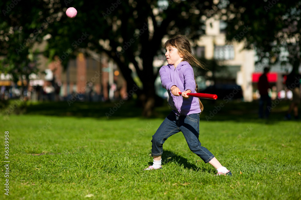 Child girl playing baseball in park Child girl playing baseball in park