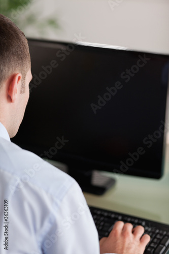 Close up of businessmans back working on his computer
