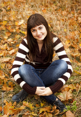 Portrait of brunette girl in the autumn park.