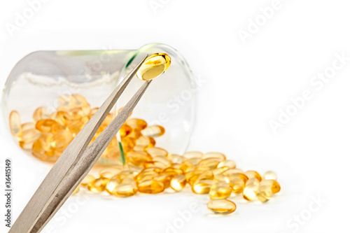 Inspection of gold pills against a white background