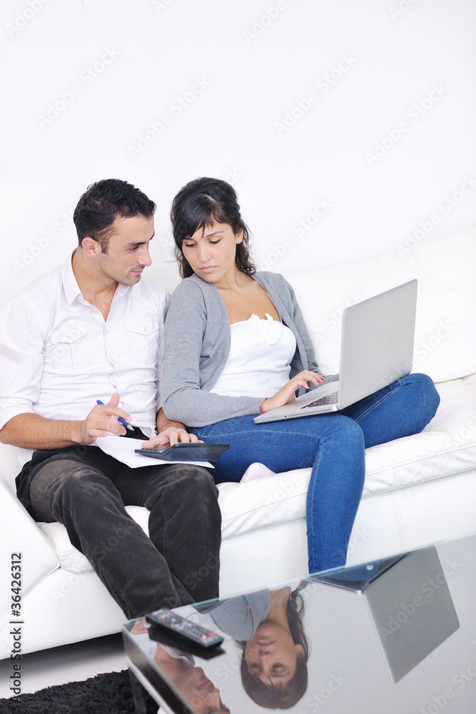 joyful couple relax and work on laptop computer at modern home joyful couple relax and work on laptop computer at modern home