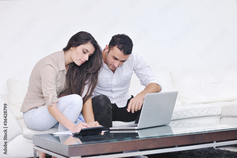 joyful couple relax and work on laptop computer at modern home joyful couple relax and work on laptop computer at modern home