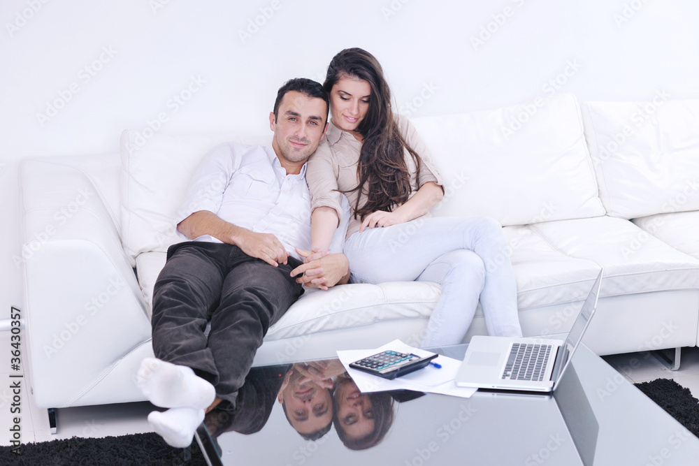 joyful couple relax and work on laptop computer at modern home joyful couple relax and work on laptop computer at modern home