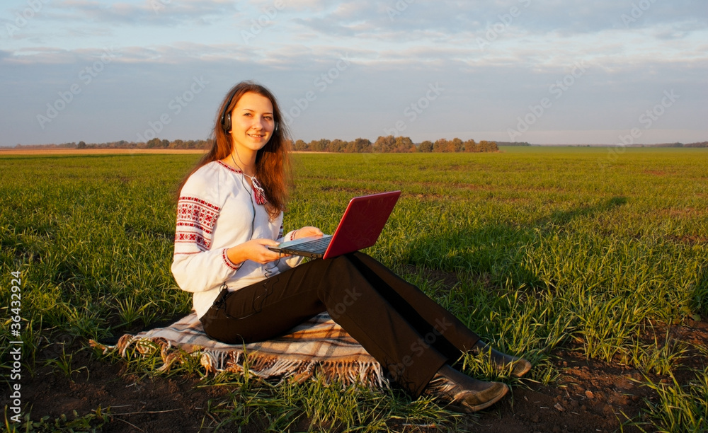 Young lady sitting outdoors with a laptop