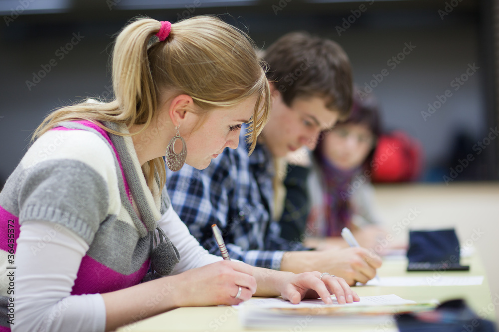 pretty, female college student sitting in a classroom pretty, female college student sitting in a classroom