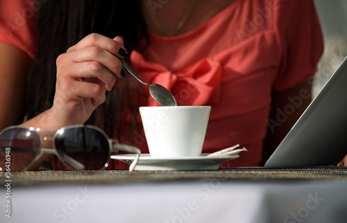 Woman drinking coffee and reading the e-book