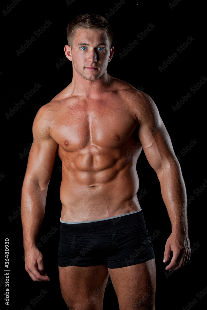Muscle sexy young naked man posing in studio