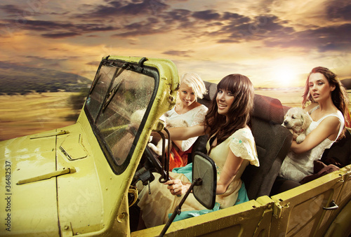 Adorable young ladies driving a cabriolet