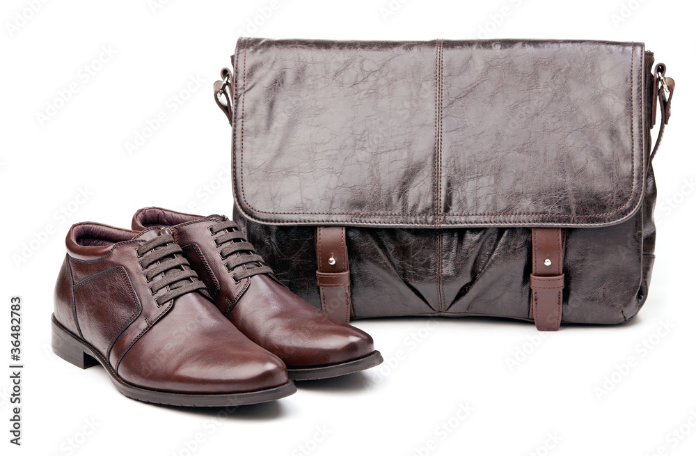 Pair of men boots and messenger bag over white Pair of men boots and messenger bag over white