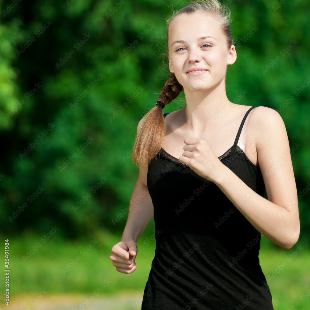 Young woman running in green park Young woman running in green park