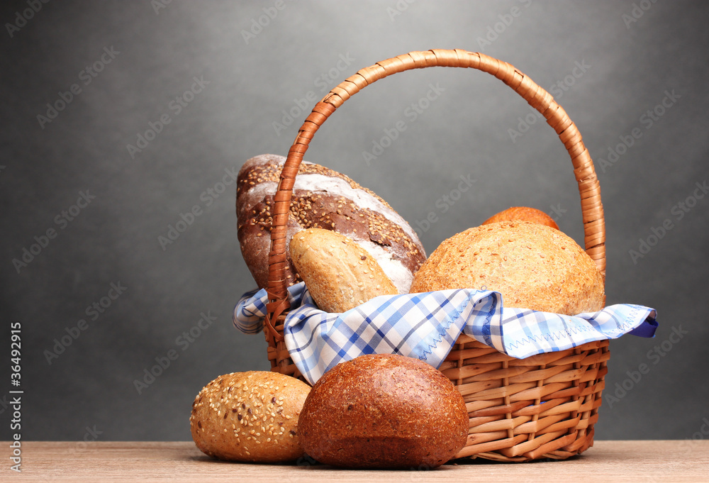 delicious bread in basket on wooden table on gray background delicious bread in basket on wooden table on gray background