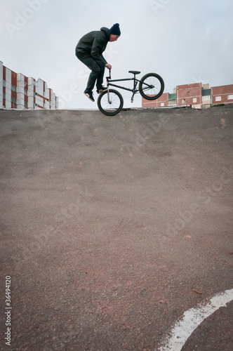 Biker doing footjam tailwhip trick photo