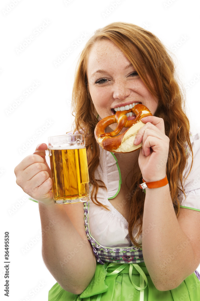 junge rothaarige frau in dirndl hält bier und isst brezel Stock Photo ...