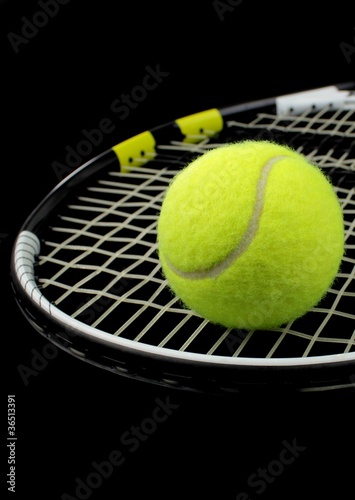 Tennis racket and tennis bal on black background