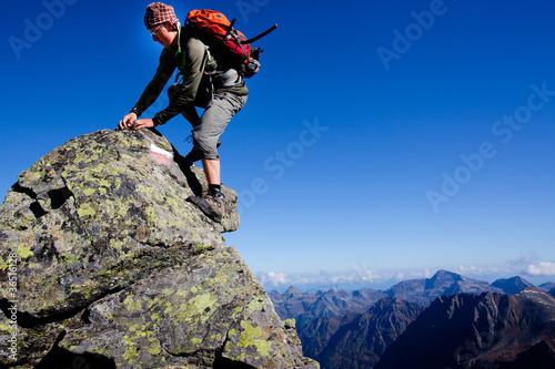 Young man climbing the mountain ridge