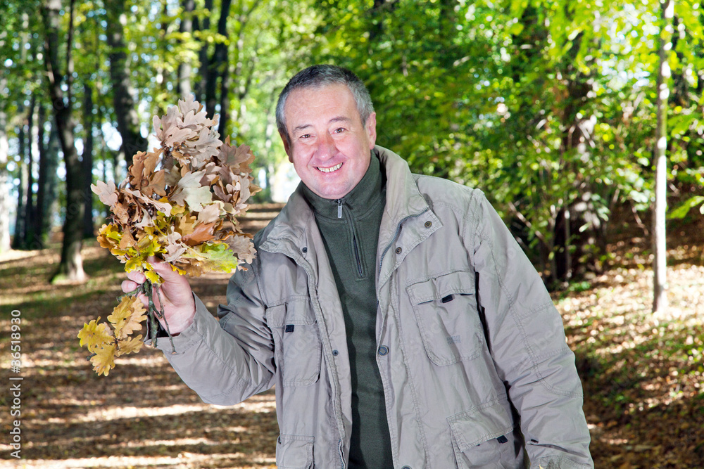 Mann mit herbstlichen Blattwerk und Zweigen Mann mit herbstlichen Blattwerk und Zweigen