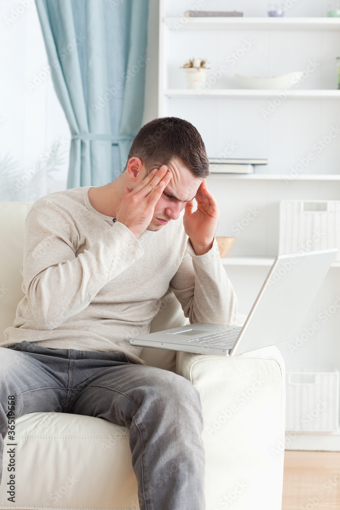 Portrait of a tired man using a laptop