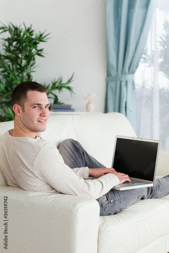 Portrait of a man lying on his couch with a notebook Portrait of a man lying on his couch with a notebook