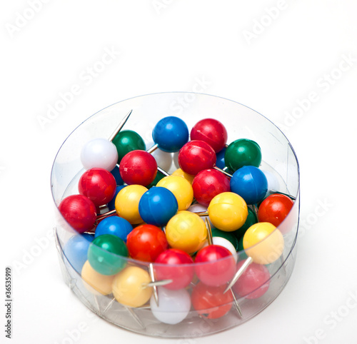 a bunch of pushpins in a box on white background