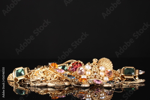 Various gold jewellery on black background