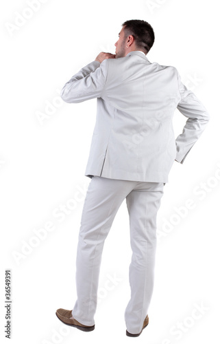 Back view of  thinking young business man in  white suit.