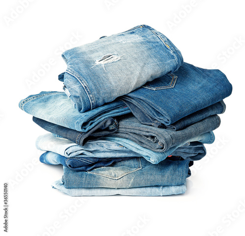 Stack of blue jeans over white