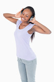 Close up of woman listening to music with headphones on white ba