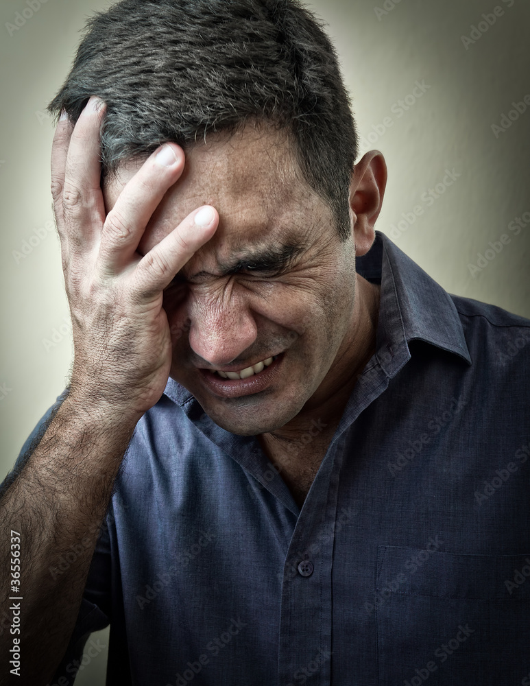 Fototapeta premium Tired disturbed man with a strong headache