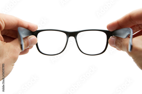Human hands holding retro style eyeglasses