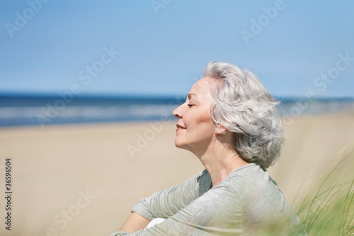 attraktive, grauhaarige Frau genießt das Meer