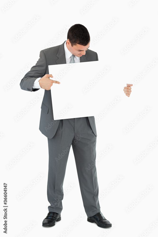 Businessman pointing at sign in his hands Businessman pointing at sign in his hands