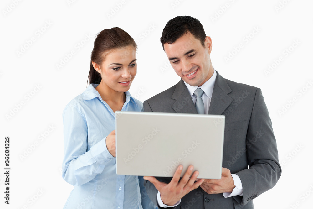 Business partners looking at laptop together Business partners looking at laptop together