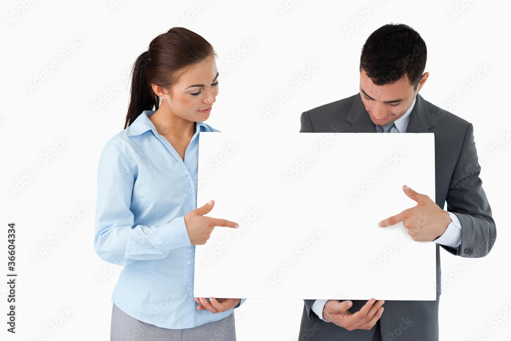 Business partners pointing at sign they are presenting Business partners pointing at sign they are presenting