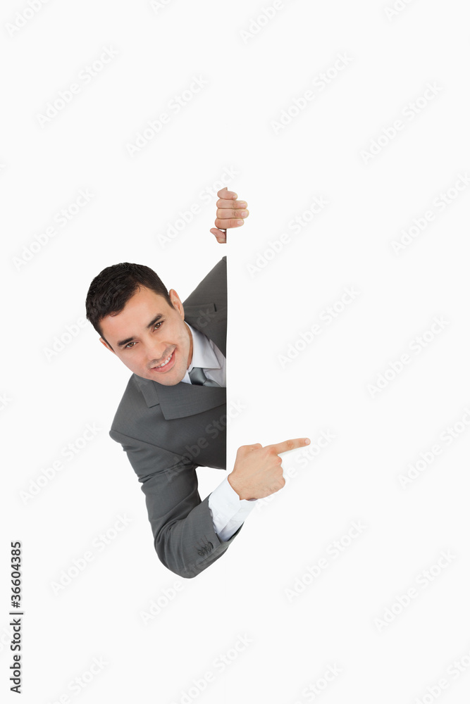 Businessman looking around the corner and is pointing Businessman looking around the corner and is pointing