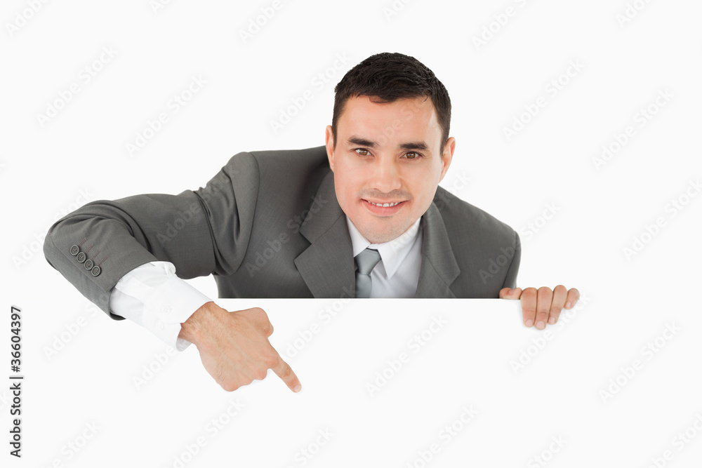 Businessman pointing at sign under him Businessman pointing at sign under him