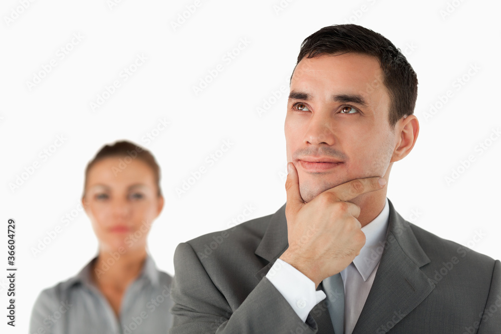 Close up of thinking businessman with colleague behind him Close up of thinking businessman with colleague behind him