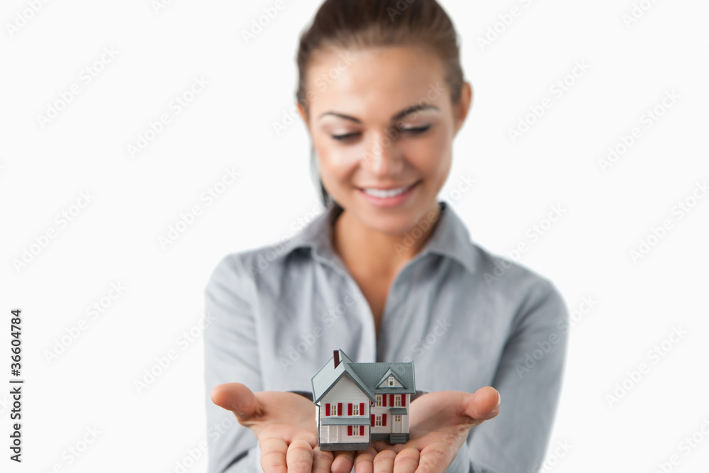 Miniature house being held by female estate agent Miniature house being held by female estate agent