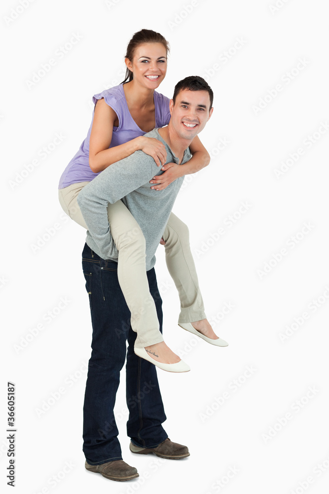 Young male carrying his girlfriend piggyback Young male carrying his girlfriend piggyback
