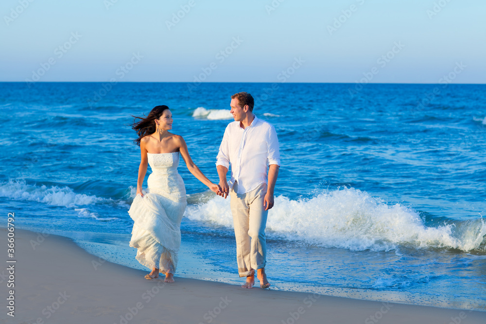 Mediterranean couple walking in blue beach Mediterranean couple walking in blue beach