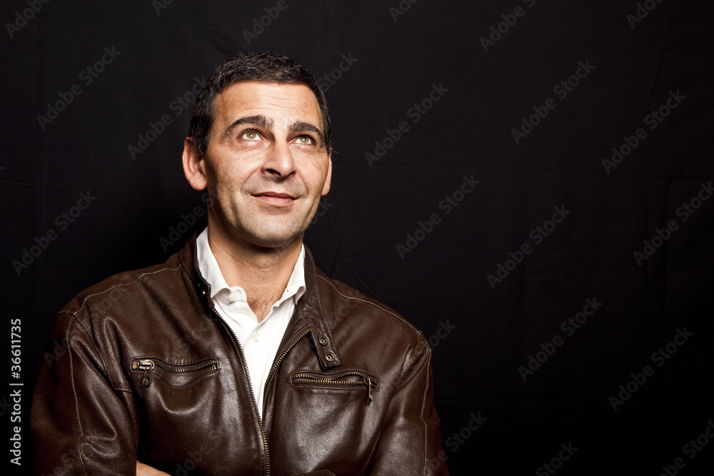 portrait of a cool mature man with leather jacket over black bac