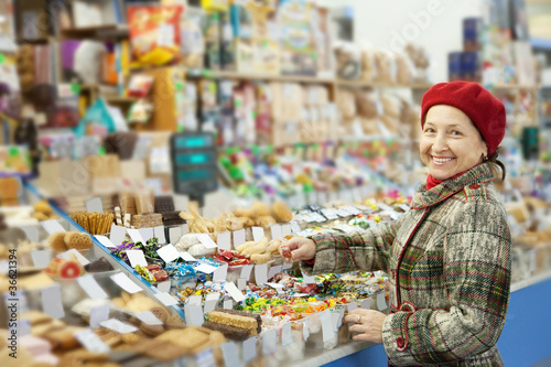 Mature woman chooses sweets