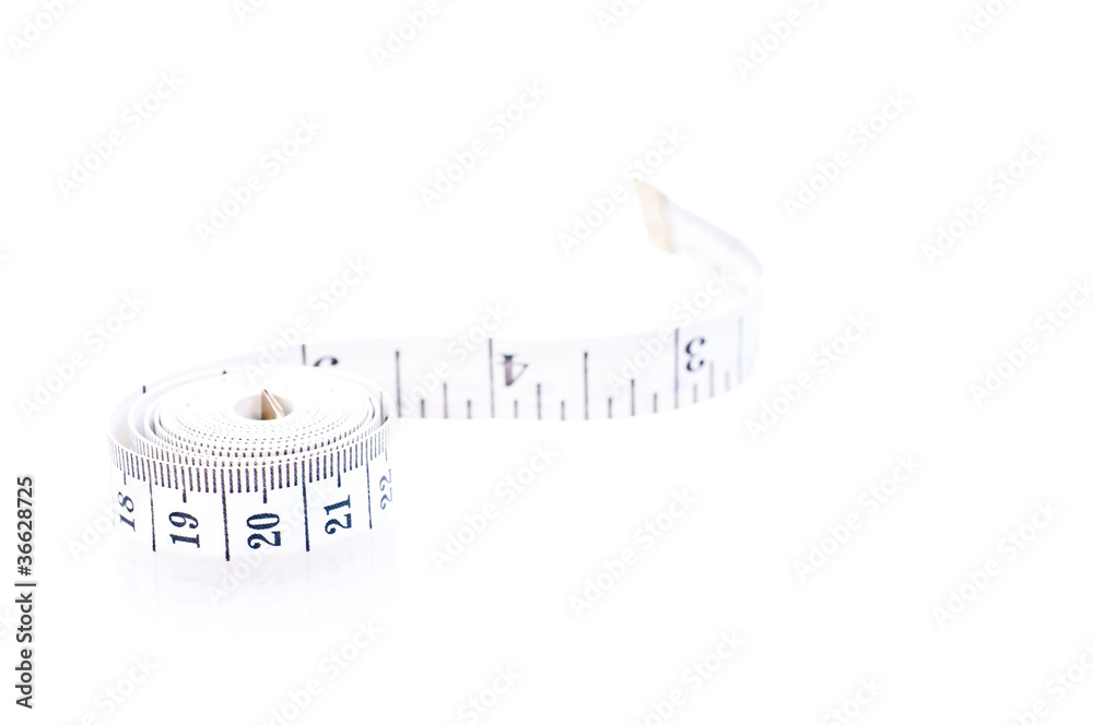Rolled black and white tape measure over white Rolled black and white tape measure over white