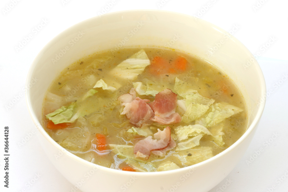 Vegetable cabbage soup in white bowl with bacon pieces Vegetable cabbage soup in white bowl with bacon pieces