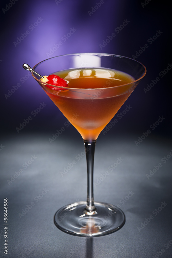 Manhattan cocktail garnished with a cherry and lemon